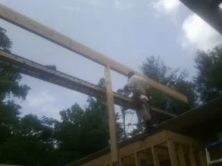 Carpenter setting a ridge beam over a new addition frame — Ice Dam Removal by Roofing Brothers in Baldwin City