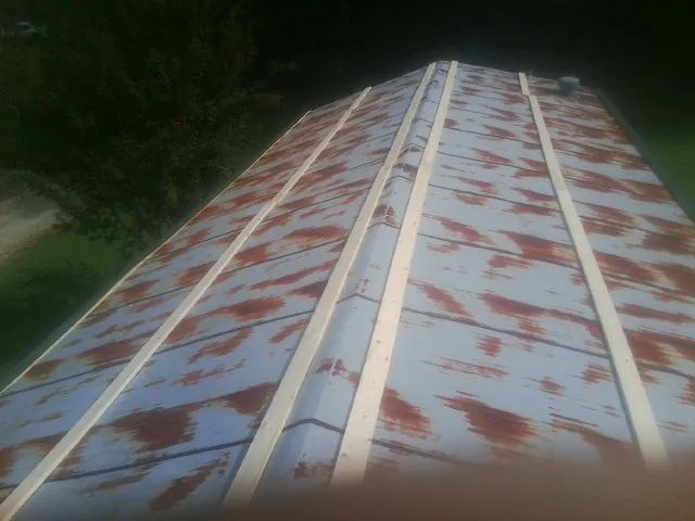 Rusted metal roof panels with new wood purlins before replacement — Storm Damage Roof Repair in Baldwin City by Roofing Brothers