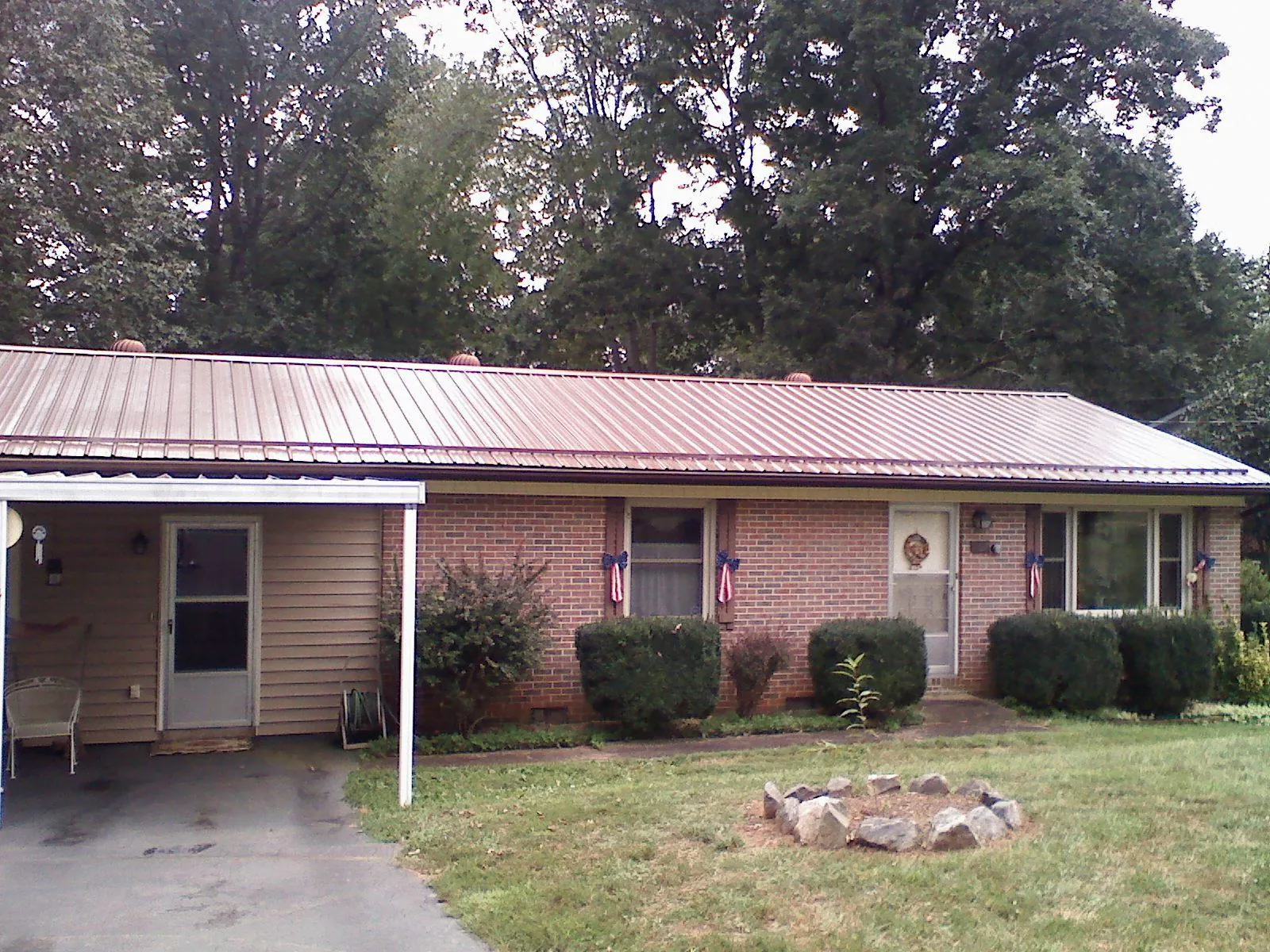 Bronze metal roof and carport on a brick ranch home — Roof Repair work by our crew in Baldwin City