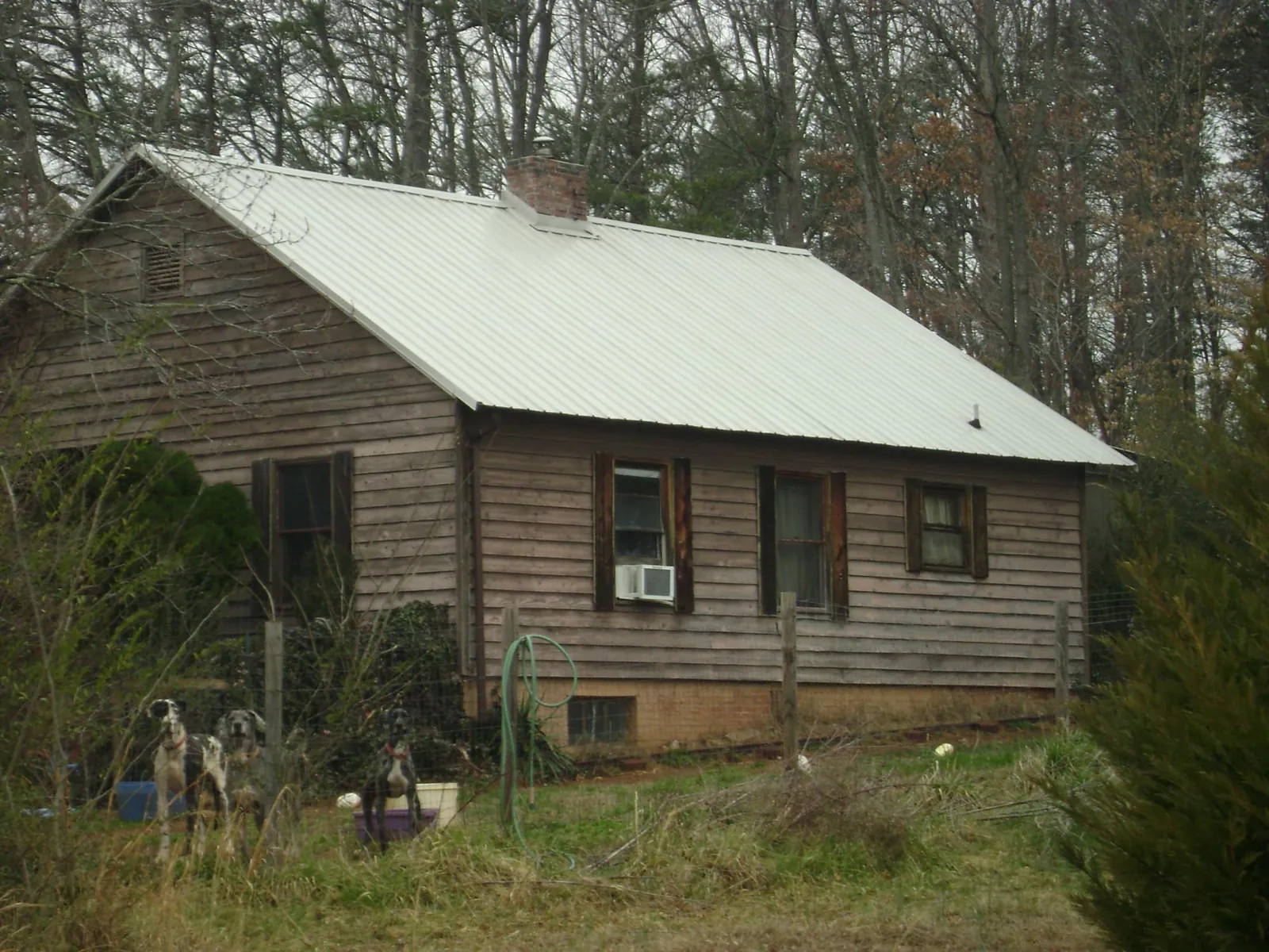 White metal roof on an old wood sided farmhouse, from a Metal Roof Installation job in Baldwin City